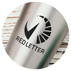 Stainless steel tumbler with engraved Redletter logo featuring a bold circular checkmark design.