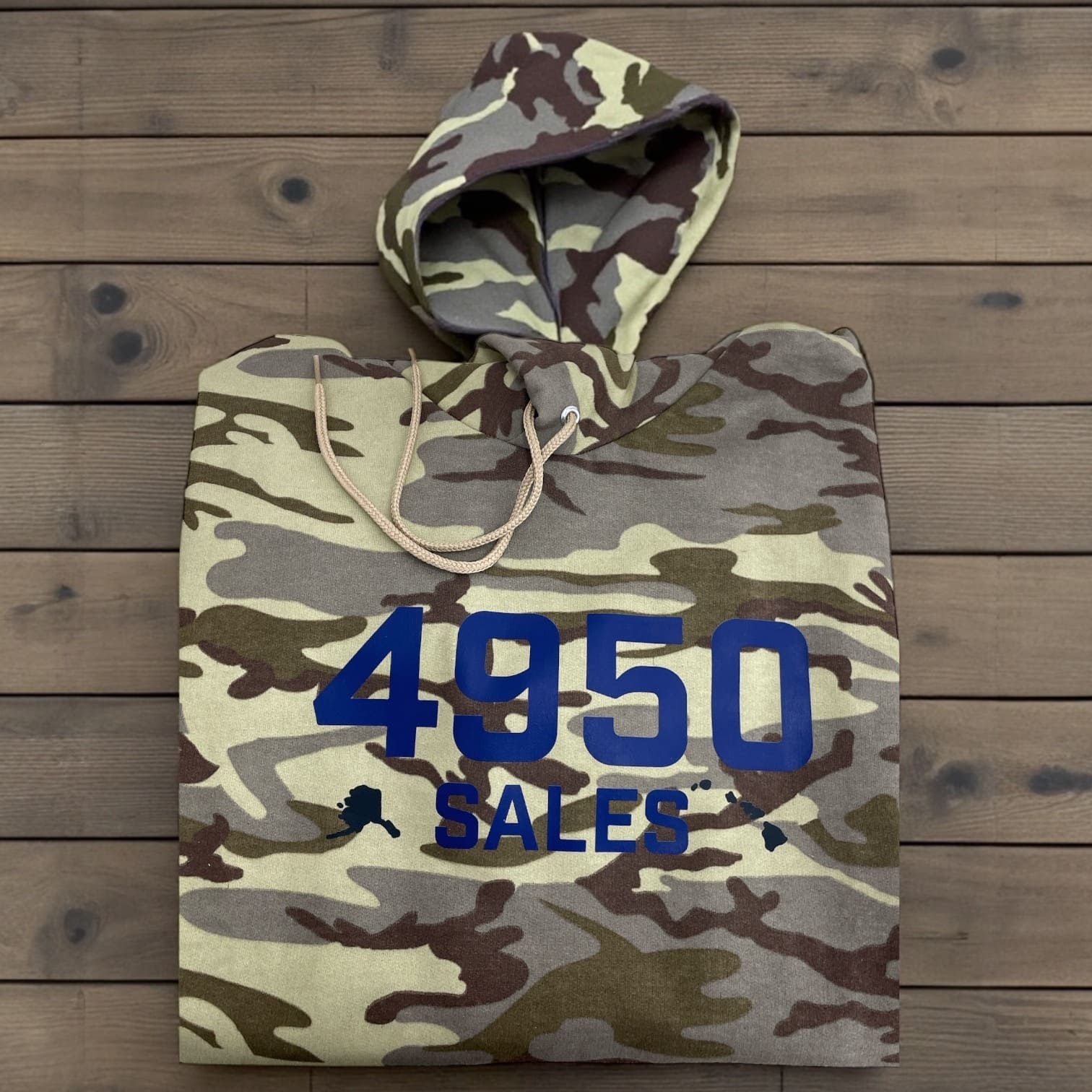 Camouflage 4950 Sales hoodie folded flat, bold blue '4950 SALES' print on front.