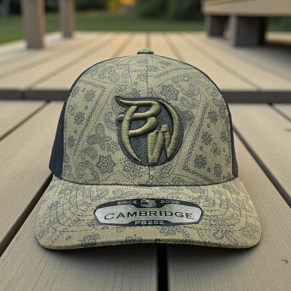 Cambridge PB252 paisley trucker hat with embroidered PW logo, olive patterned front, black mesh back, curved brim.