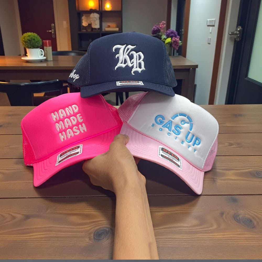 Custom trucker hats: navy KB monogram cap, pink HAND MADE HASH cap, and white/pink GAS UP RECOVERY hat.