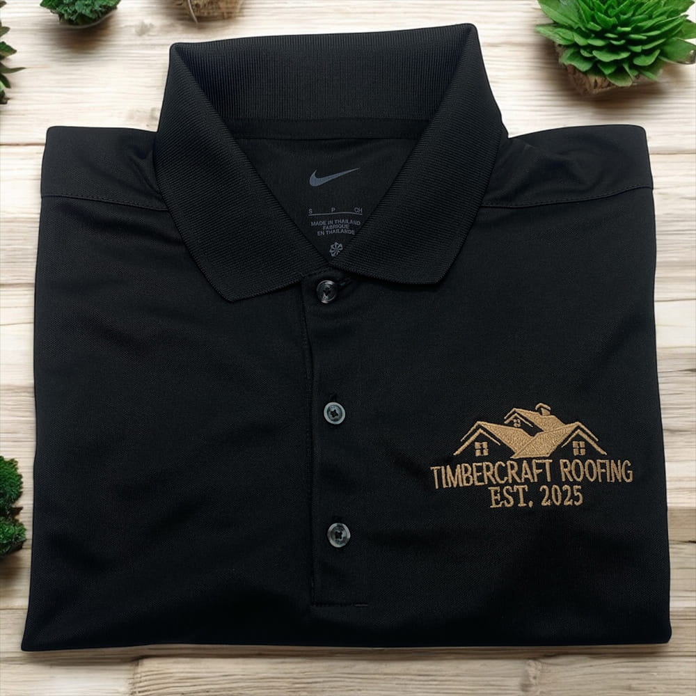 Black Nike polo shirt with gold embroidered Timbercraft Roofing logo and house graphic, Est. 2025, custom workwear.