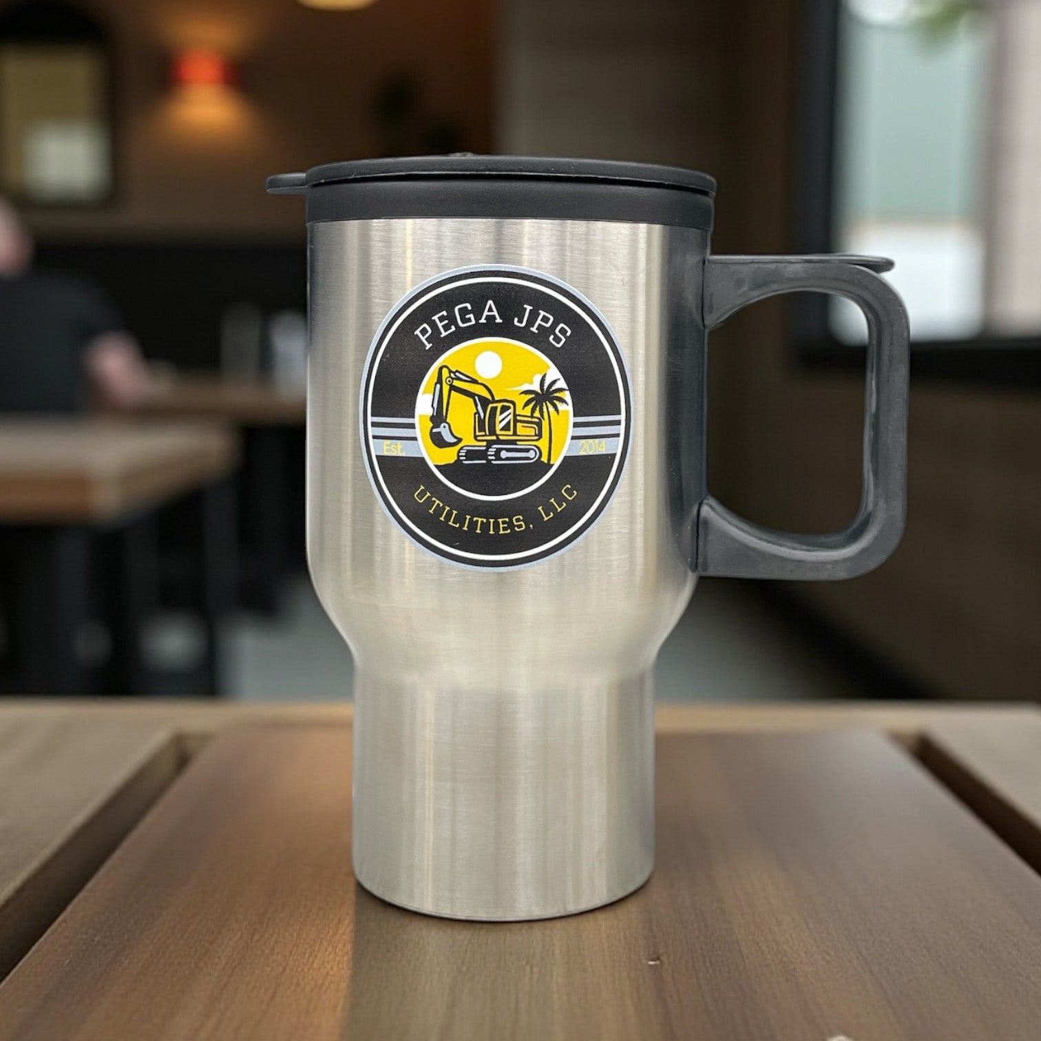 Stainless steel handled travel mug with Pega JPS Utilities, LLC logo featuring excavator and palm tree icon.