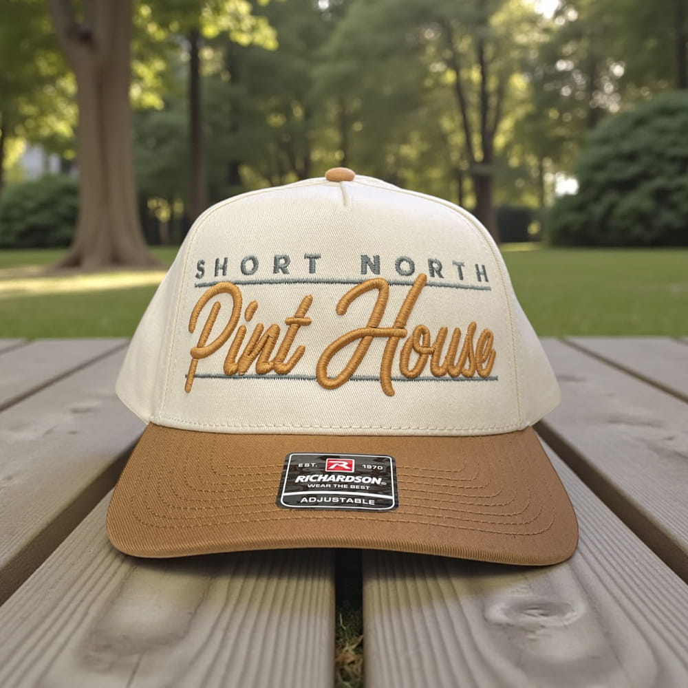 Cream and tan Richardson cap with embroidered Short North Pint House logo in gold script, adjustable curved brim hat.