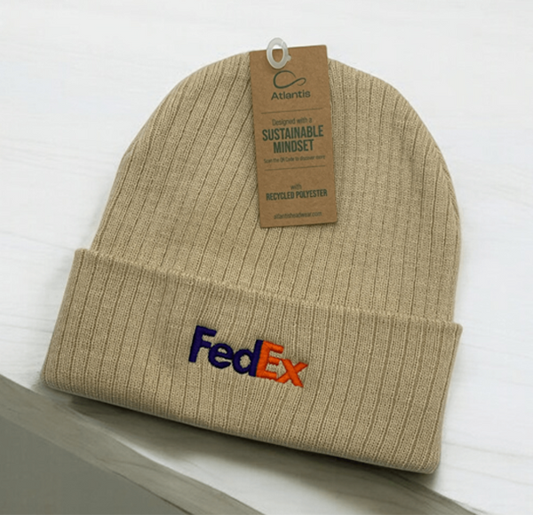 Beige FedEx branded beanie made with recycled polyester, tagged with Atlantis Headwear's sustainable mindset label.